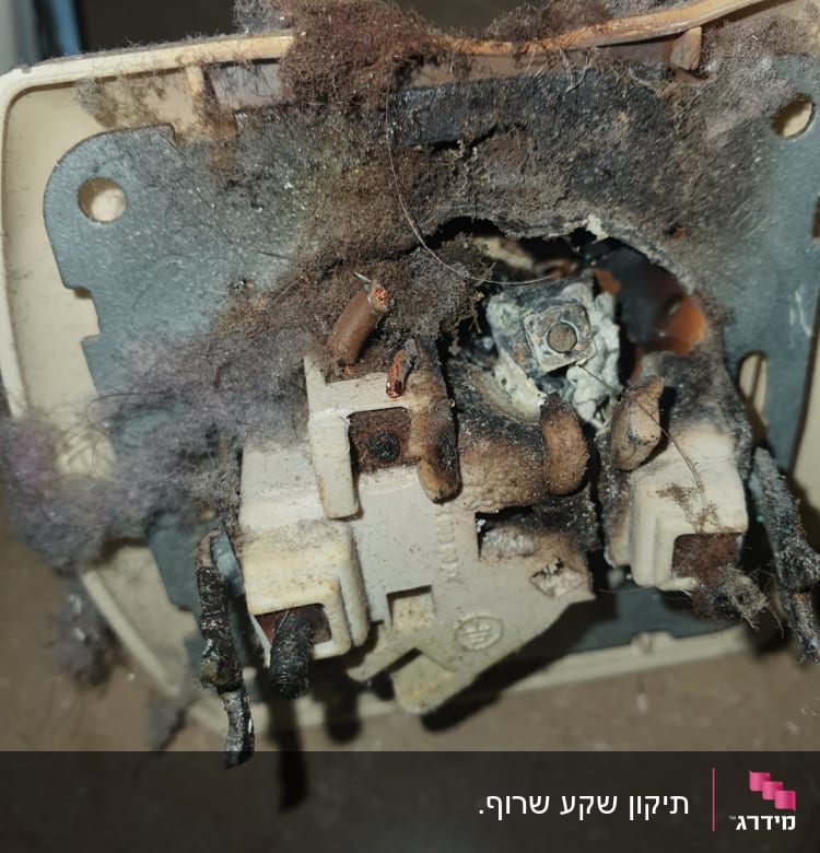 שקע חשמלי שרוף עם חוטים חשופים ולכלוך